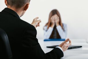 Depressed young woman during a conversation with the boss who points out her mistakes